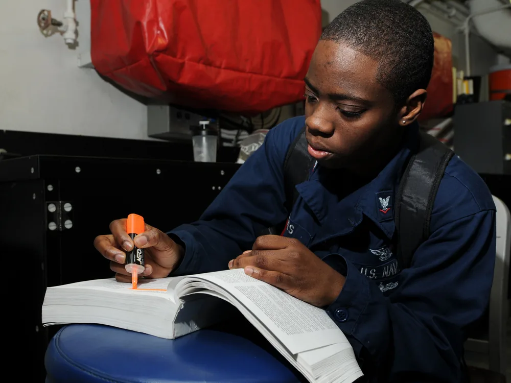A person studying for a professional exam with prep materials